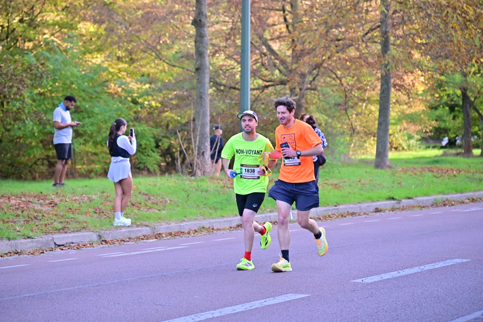 Alexandre et son guide, souriants, sur une route arborée du semi-marathon du Bois de Vincennes.